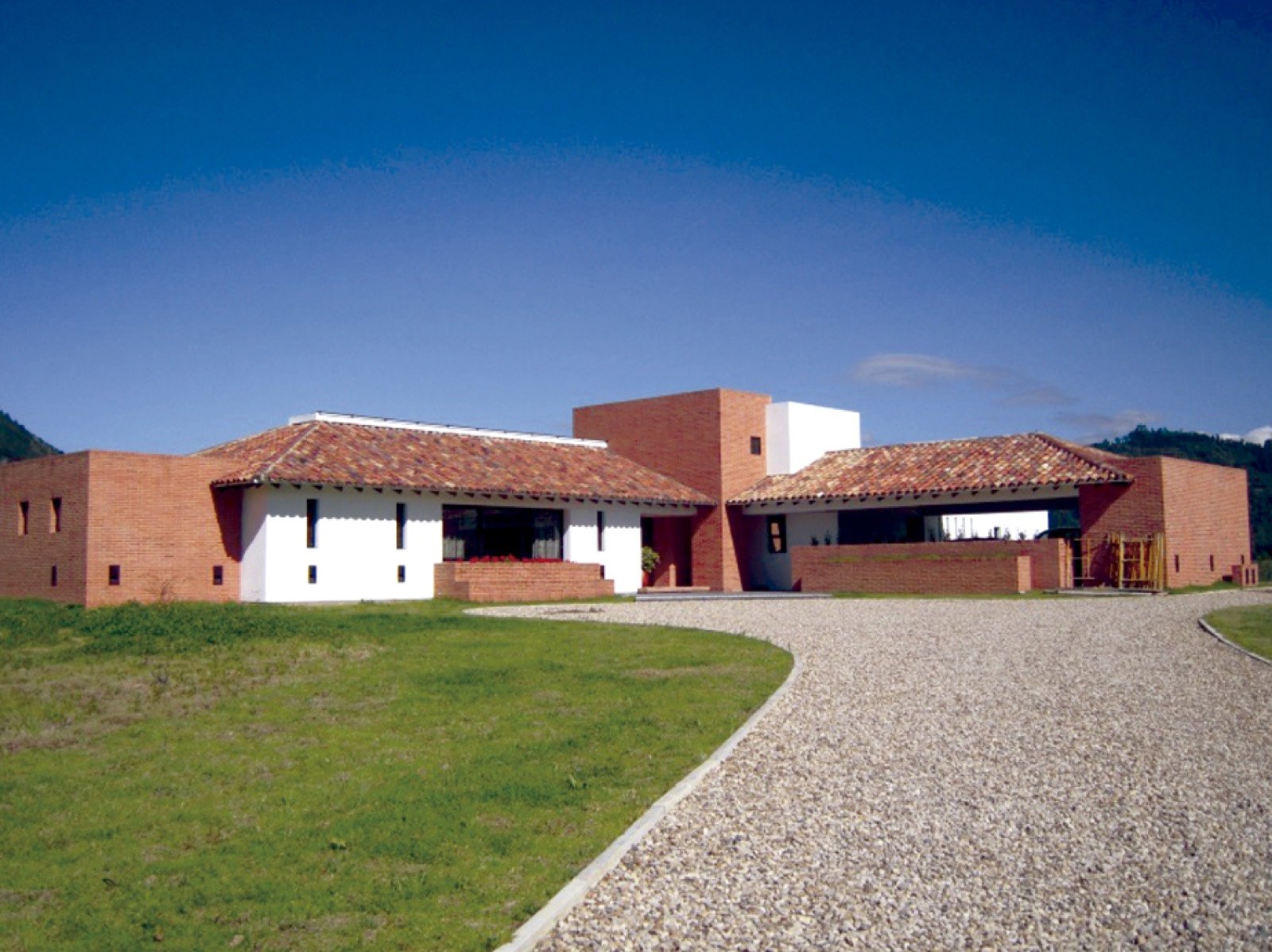 Casa campestre en ladrillo con cubiertas de teja y acceso en gravilla