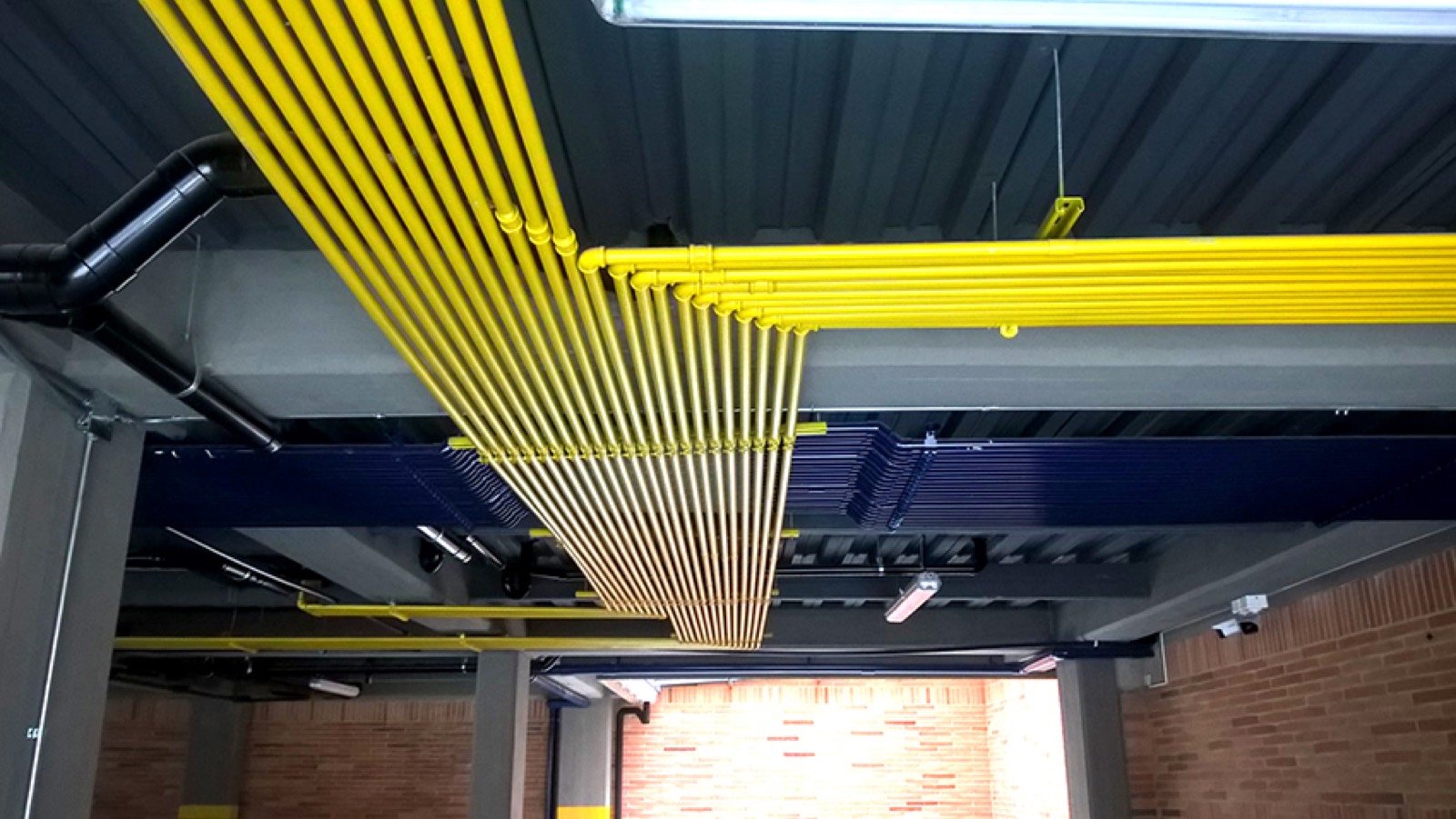 Tuberías de gas amarillas instaladas bajo placa en sótano